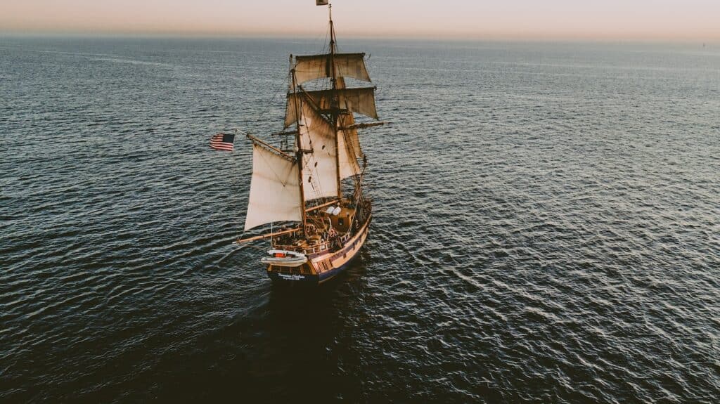 brown sailboat in beach under white sky